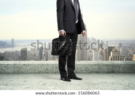 businessman standing with briefcase on concrete roof