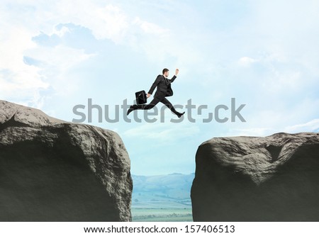 young businessman jumping at drawing rock