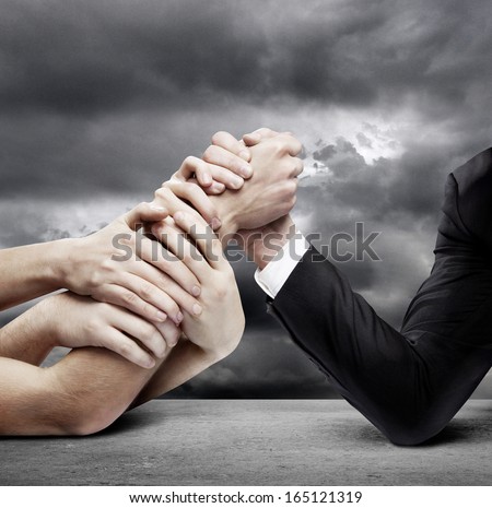 arm wrestling: businessman in opposition with many hands
