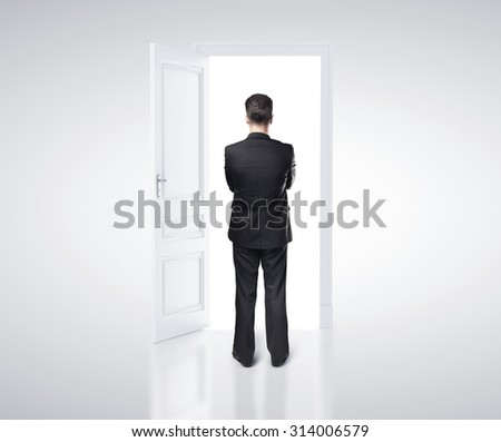 businessman in white room with doors open