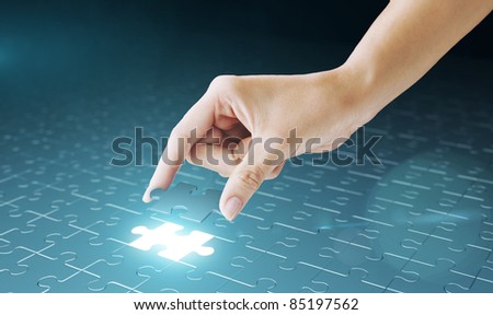 Hand embed missing puzzle piece into place. Business concept for completing the final puzzle place