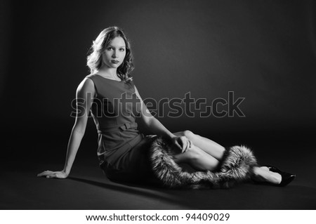 Luxurious woman posing on black in black and white.