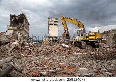Bulldozer Removes the Debris From Demolition of Old Derelict Buildings on the Construction Site