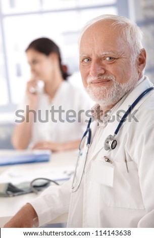 Portrait of senior doctor smiling at doctor\'s room.