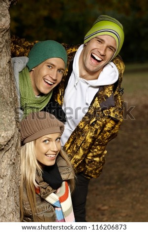 College students having fun in autumn park, smiling.