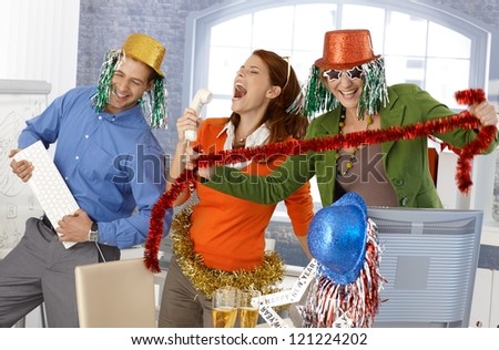 Festive new year office party, office workers having fun with accessories.