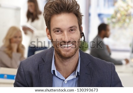 Closeup portrait of handsome male customer service representative smiling happy.