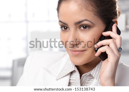 Closeup portrait of businesswoman listening to mobile phone call, smiling.