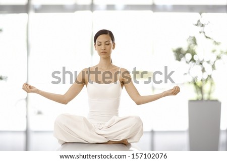 Beautiful young woman practicing yoga, relaxing eyes closed.
