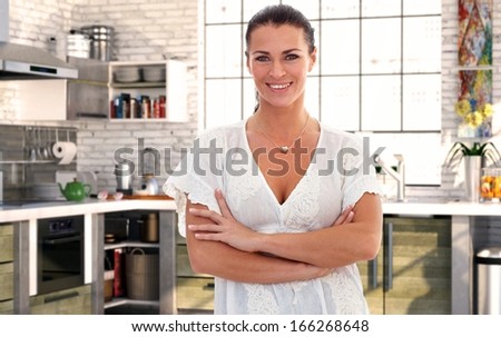 Portrait of smiling housewife over 40 in kitchen at home.