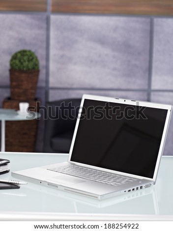 Closeup photo of open laptop placed on desk.
