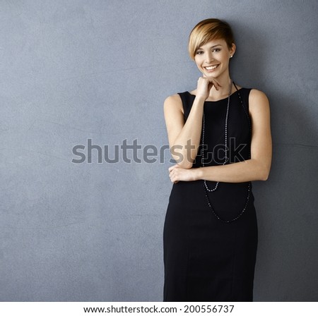 Beautiful young woman in cocktail dress on gray background