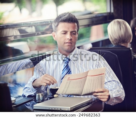 Elegant businessman traveling on luxury train, having coffee reading newspaper. vintage effect.