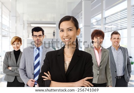 Happy asian businesswoman leading team of business people.