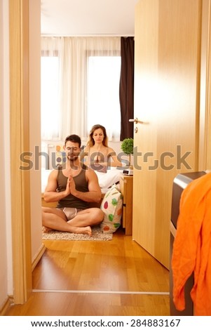 Young couple on holiday starting the day with meditation.