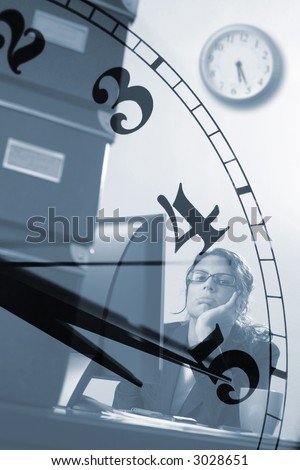Bored young female officeworker thinks of the time when business hours end.