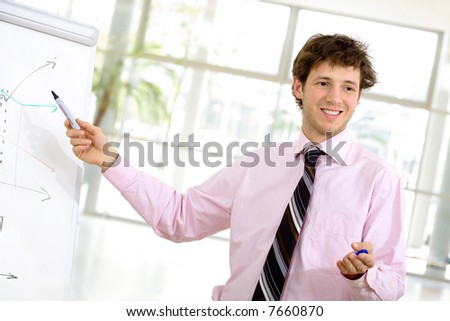 Young businessman doing presentation on whiteboard.