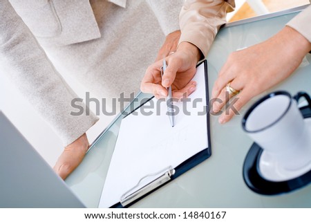Close-up of female hands working with documents on table.