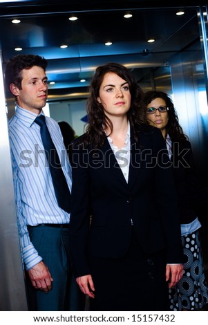 Young business people standing in elevator.