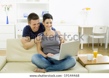 Couple shopping on internet paying by credit card.
