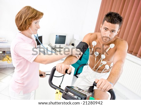 Nurse makes the patient ready for medical EKG test. Real people, real locacion, not a staged photo with models.