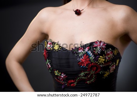 Closeup photo of a cocktail dress showing flower embroidery details.