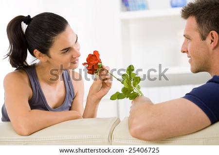 Romantic man giving red rose to woman on Valentine\'s Day.