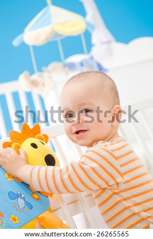 Happy baby boy ( 1 year old ) playing at home, smiling. Toys are property released.