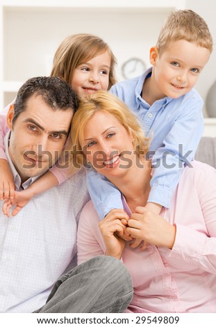 Portrait of happy family, children embracing their parents from behind.