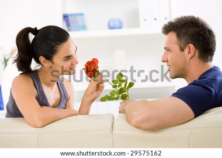 Romantic man giving red rose to woman for Valentine\'s Day.
