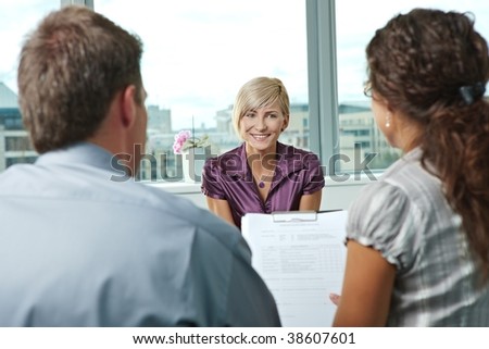 Happy woman applicant talking during job interview. Over the shoulder view.