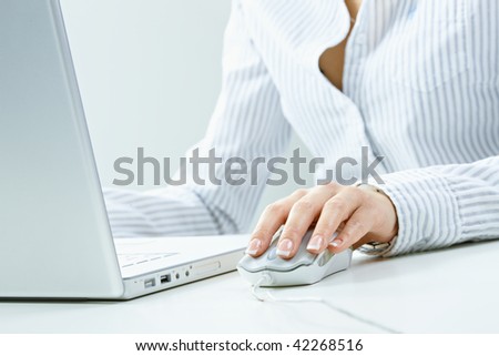 Closeup of female fingers and nails on computer mouse.