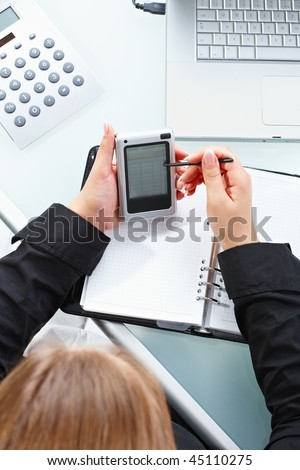 Female hand using touch screen handheld computer with stylus.
