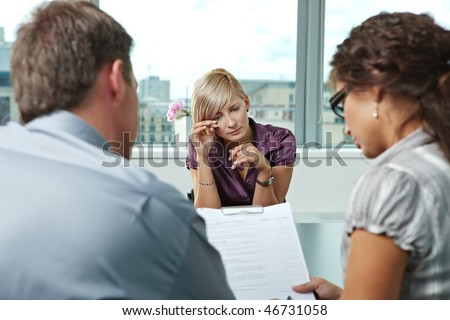 Woman applicant crying during job interview. Over the shoulder view.