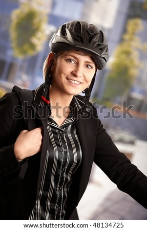 Portrait of young businessman wearing bike helmet, going to work, smiling.
