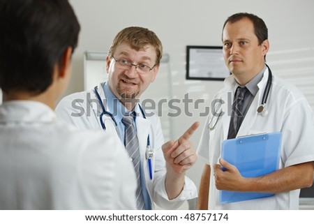Medical office - doctors having consultation at office, talking, smiling.