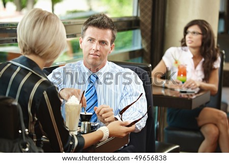 Young businessman and businesswoman having a meeting in cafe.