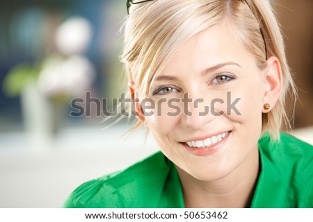 Closeup portrait of happy young businesswoman wearing green shirt, smiling.