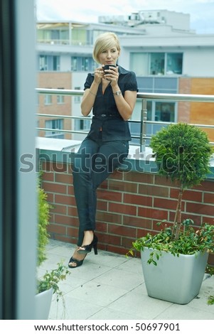 Businesswoman having break on office terrace outdoor drinking coffee.