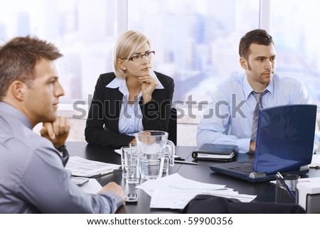 Serious businesspeople focusing on work in office, looking at colleagues out of frame.?