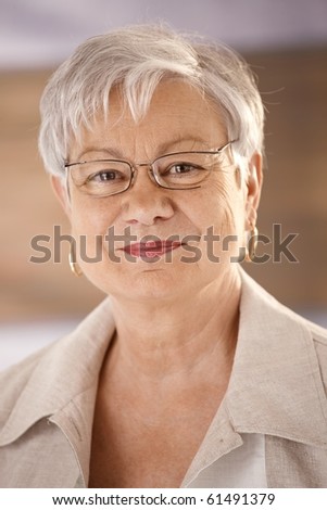 Closeup portrait of happy senior woman wearing glasses, looking at camera, smiling.?