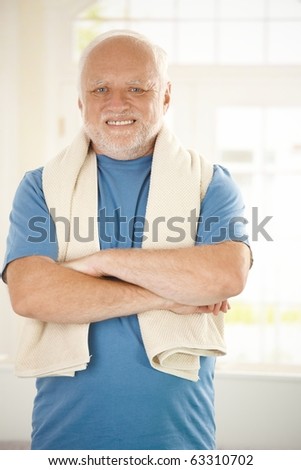 Portrait of smiling active senior in sportswear, smiling with arms folded, looking at camera.?