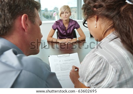 Woman applicant worrying during job interview. Over the shoulder view. Focus placed on sheet in front all results are bad.?