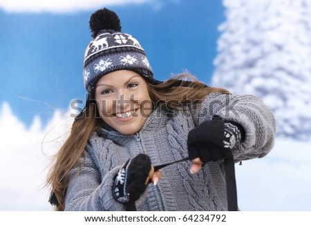 Young female having winter fun, being drawn by sleigh, smiling.?