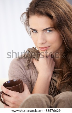 Attractive young female drinking tea, smiling.?