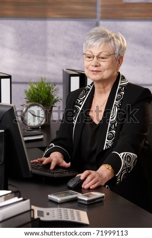 Portrait of senior businesswoman working with computer at desk in office.?