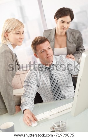 Business team at work, looking at computer screen in office.?