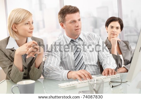 Concentrating businesspeople on meeting, looking at computer screen.?