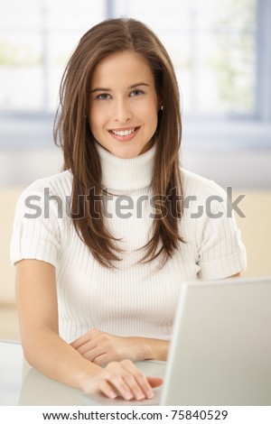 Portrait of smart woman with laptop computer, smiling at camera.?