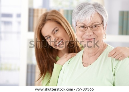 Portrait of elderly mother and daughter smiling happily.?